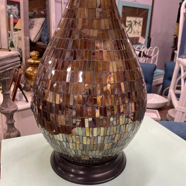 Larger scale teardrop shaped table lamp has an array of small rectangular smoke colored mirrors forming its entire base....