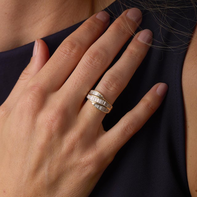 This striking vintage band showcases a refined arrangement of 38 baguette and tapered baguette cut diamonds totaling...