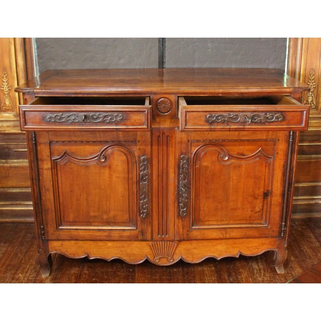 Circa 1780 Louis XVI period country French buffet. Cherry with original cut steel hardware. Whorl carved, molded, panelled...