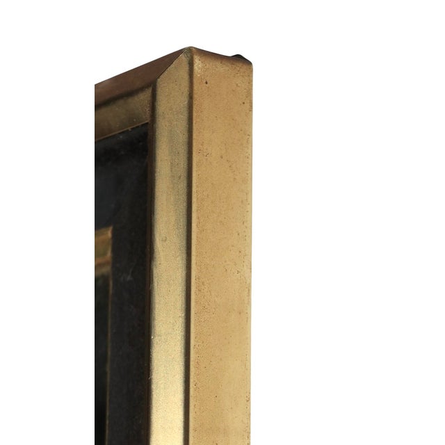 Chic tailored vintage wall mirror, by the Turner Glass Company, circa 1950/70's. The mirror features a gold and black...