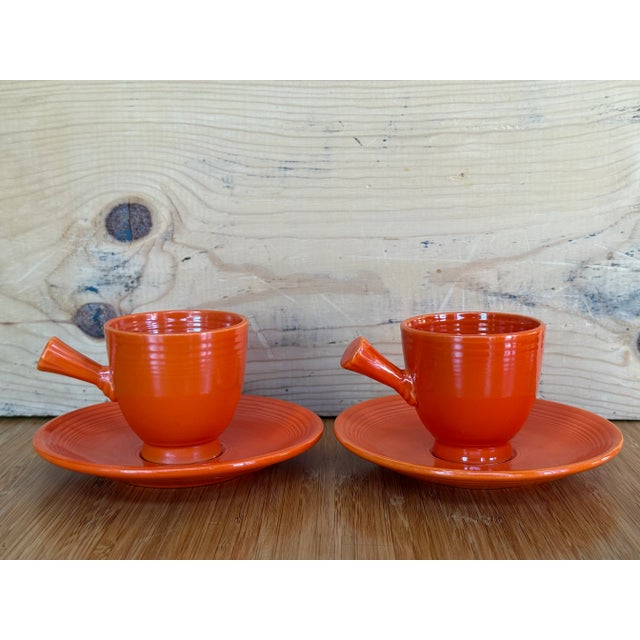 This orange cup is part of a cup and saucer set of Fiestaware, from the USA. Uranium oxide was used in the glaze, which...