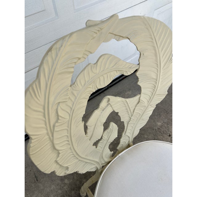Vintage Hollywood Regency Cast Aluminum Dining Chair with banana leaf motif. They have been painted cream color and boasts...