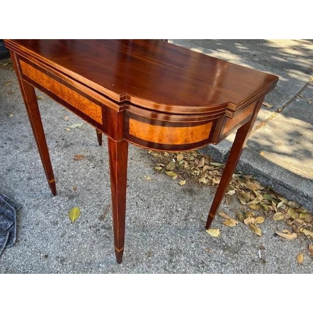 This antique Federal style game table is made of mahogany with satinwood inlay, showcasing intricate craftsmanship and a...