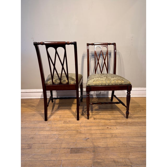 This elegant pair of Regency-style mahogany side chairs has been professionally restored and newly upholstered in high-end...