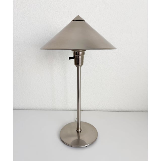 Late 20th century postmodern table lamp with sculptural conical shade. Features a brushed stainless steel finish, weighted...