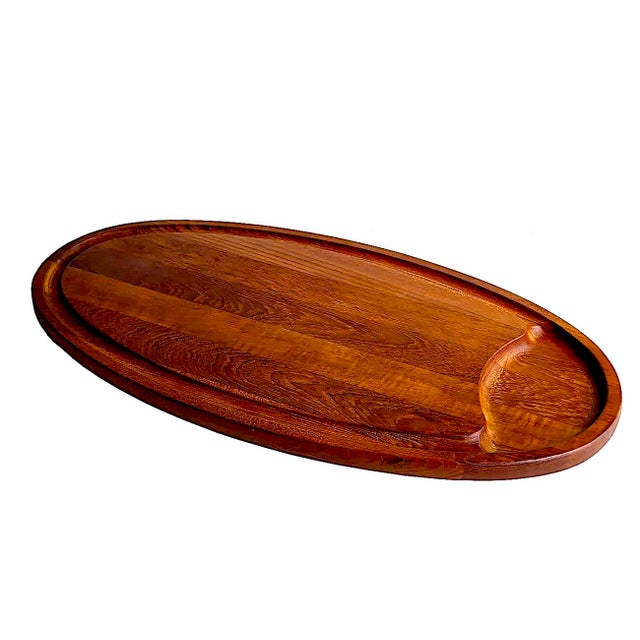 Offered is one of Dansk's iconic charcuterie boards in teak wood designed by Jens H. Quistgaard. It is a sleek, elongated...