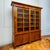 Large-scale Biedermeier bookcase featuring a four-door lower case articulated by pilasters. Above, a slightly recessed...
