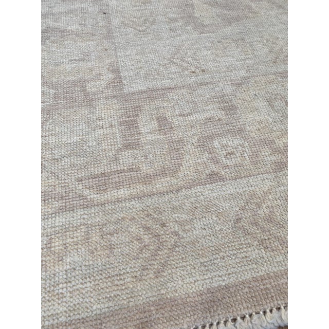 A lovely muted vintage Oushak rug. This vintage Oushak offers a muted palette with accents of a very faded light purple.