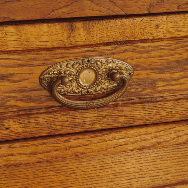 This chest of drawers, created around 1900 in the Louis XVI style, combines a clearly structured oak frame with a white...