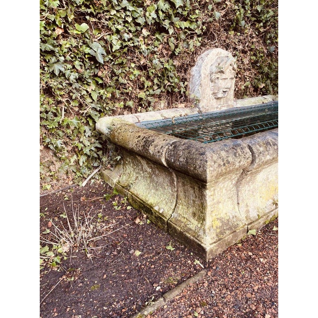 Stone fountain and outdoor basin. The head of a young boy with an open mouth allows water to flow in. Large stone...