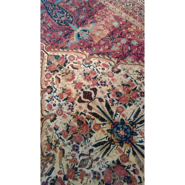 Antique rug in tones of rust and cream. Features a central medallion pattern. Origin: Persia Material: Wool