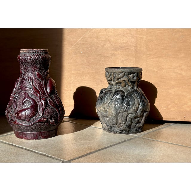 An impressive pair of antique relief vases displaying detailed exotic historical motifs with birds, echesen framed by...