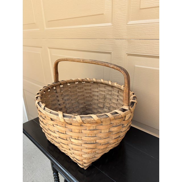 A beautifully woven early 20th century American splint oak basket with warm honeyed tones and a tightly constructed...