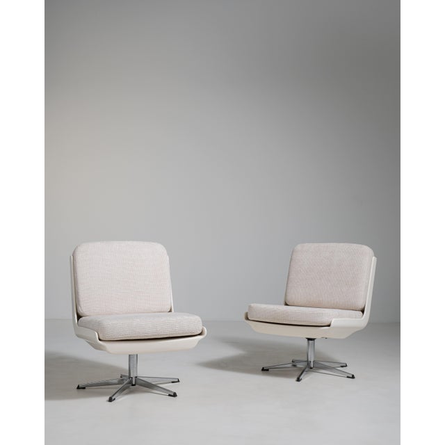 A collection of mid-century Space Age swivel chairs characterized by rounded forms and functional bases. These chairs...