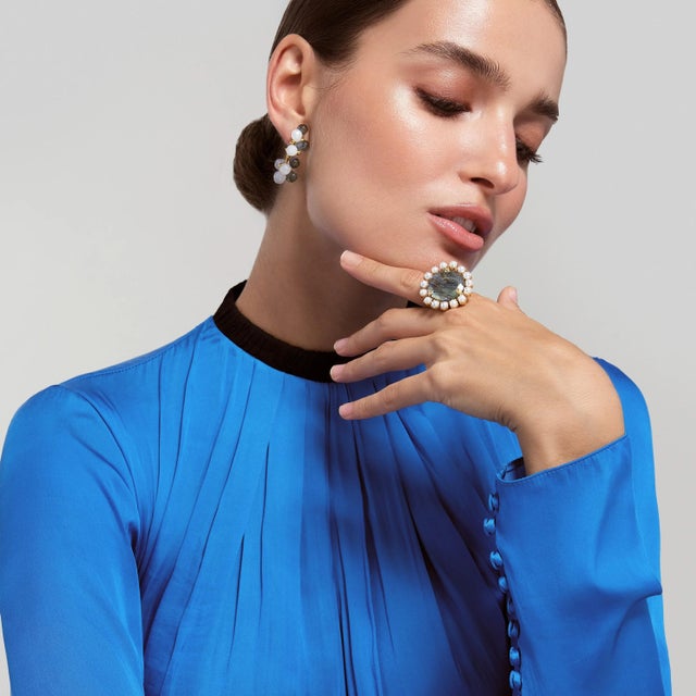 The Clementine Ring features a stunning circular semi-precious stone surrounded by an array of contrasting stones, exuding...