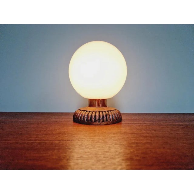 Table lamp with a white opaline globe, a wooden base and a copper ring, 1960s. The lamp is compatible with an E14 LED...