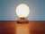 Table lamp with a white opaline globe, a wooden base and a copper ring, 1960s. The lamp is compatible with an E14 LED...