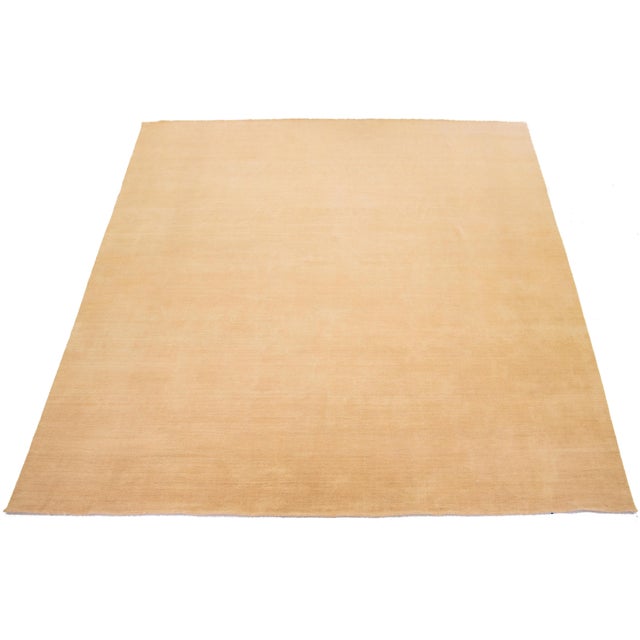 This handcrafted custom wool rug, designed in the Gabbeh style, features a solid tan design. It is part of our Desert...