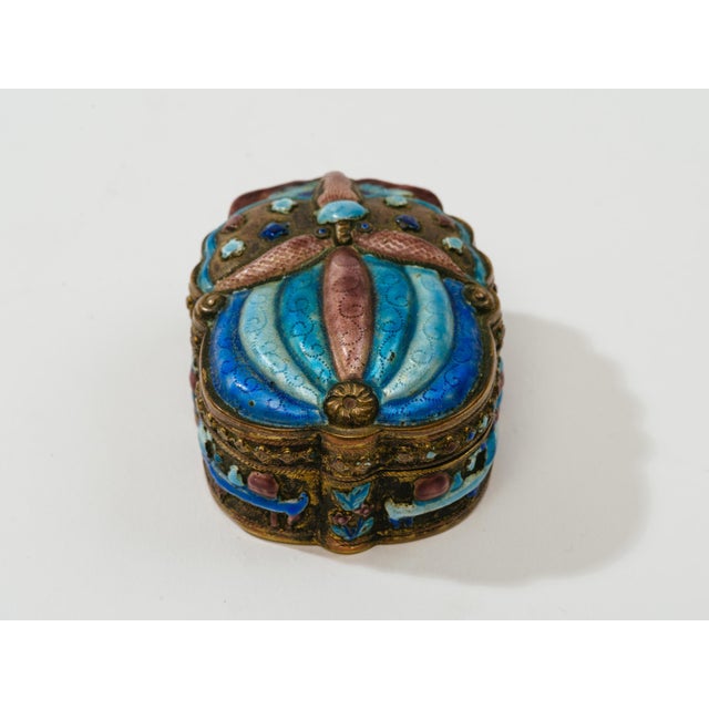 Finely detailed champlevé scarab shape box with gilt wash interior. Traces of antique mirror on inner top. Rich colors of...