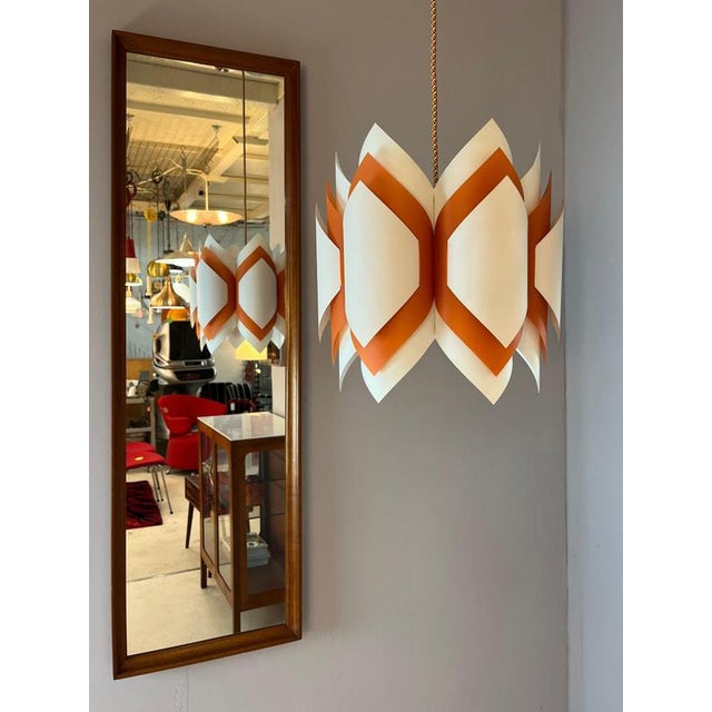 The Ballet pendant lamp in orange and white by Lars Schioler impresses with its delicate, origami-inspired design. The...