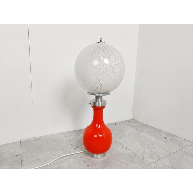 Midcentury table lamp by Mazzega with white and orange opaline glass and chrome. Beautiful midcentury lamp which emits a...