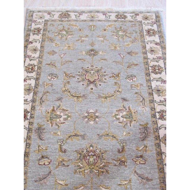 This gray wool rug features a hand knotted pile construction and represents the classic Agra style. Produced in India,...