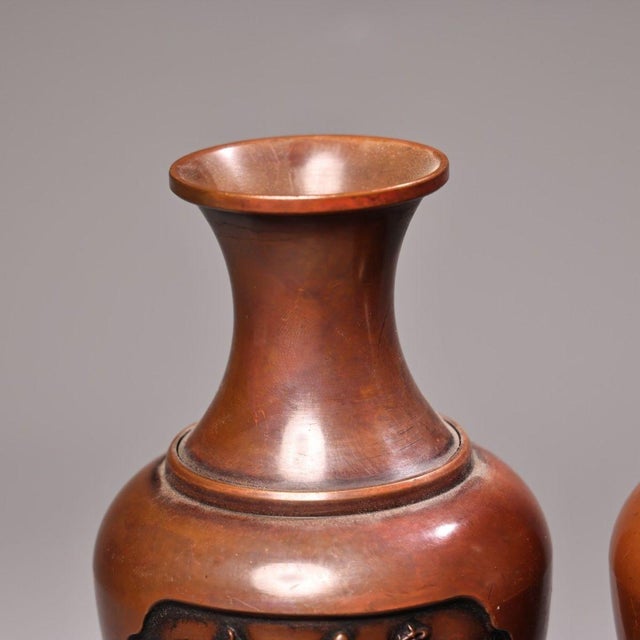 Beautiful matched pair of handcrafted solid copper vases. Each vessel features raised high-relief chased panels with a...