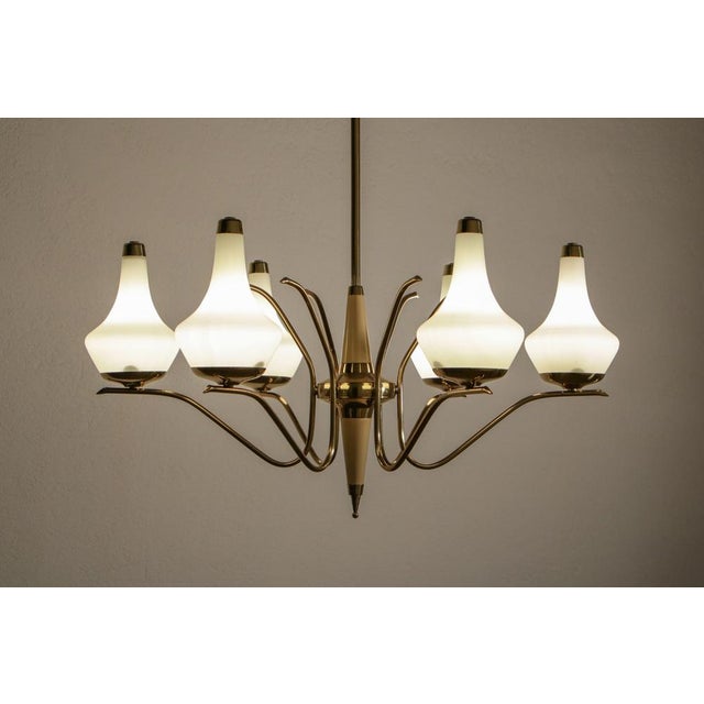 This beautiful Italian gold and ivory color chandelier from the 1950s is attributed to Stilnovo and features polished...