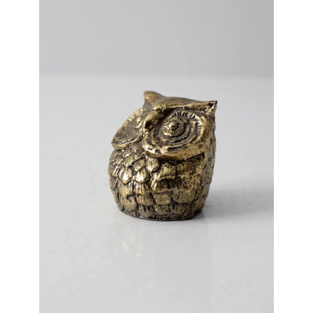 This is a mid 20th century brass owl figurine. The vintage brass sculpture features lively cast detailing with a squat...