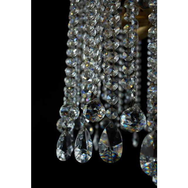 Brass chandelier with a rich cascade of crystal trimmings made of lead crystal. The trimmings are hand-cut and polished....