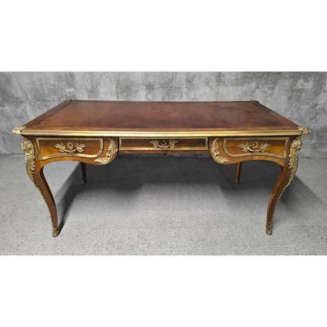 A large louis xv style flat desk, late 19th or early 20th century, crafted from mahogany wood and veneer, with marquetry...