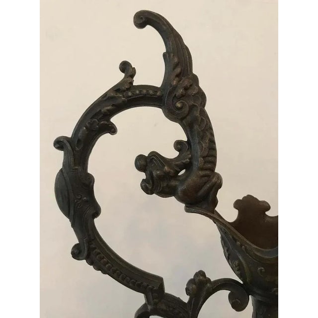 A large neo-renaissance ewer in bronze with dragon decoration. The foot has a gadroon motif and rests on a marble terrace.