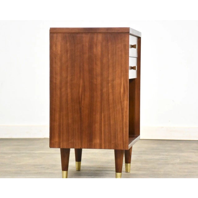 A mid century modern walnut two drawer nightstand by John Stuart. Professionally refinished. 19” wide. 14” deep. 27.5” tall.