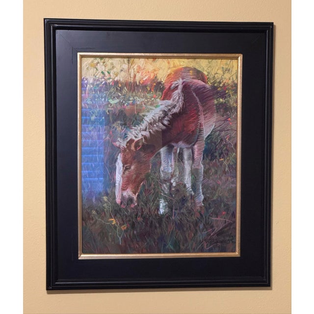 The artwork features a horse grazing in a vibrant, lush setting, captured with dynamic strokes of soft pastel that convey...