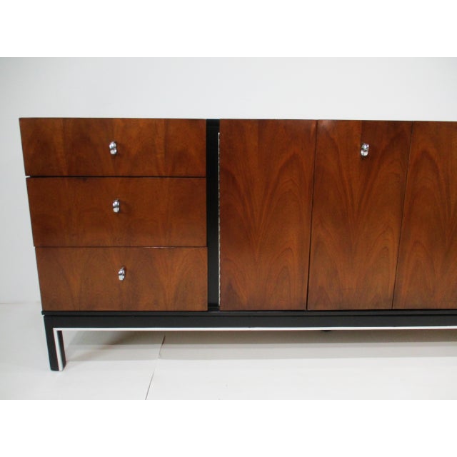 A stunning nine drawer dresser chest or credenza with walnut drawer fronts and ebony toned top and sides. The lower leg...