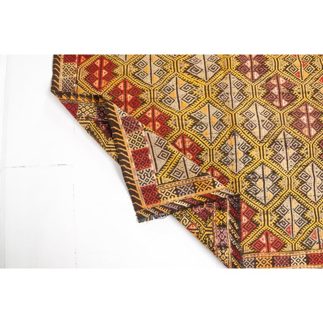 This is a vintage Turkish Oushak rug from the Mid 20th Century. The piece was hand-knotted.