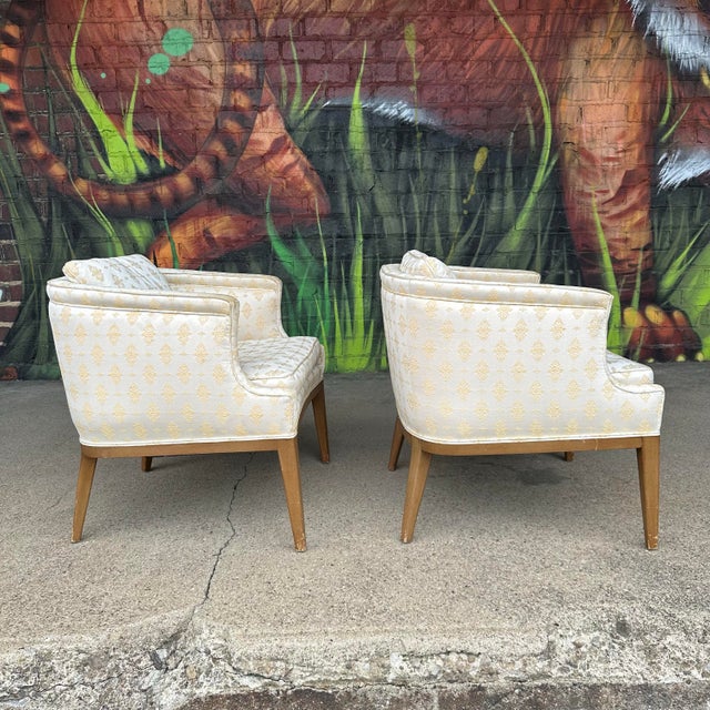 Pair of mid century modern side chairs featuring a “tub” shaped back, curved arms, and angled tapered wooden legs. Current...