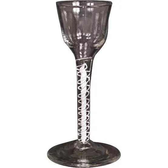 Found in Scandinavia, this antique, 18th century, twist stem wine or cordial glass displays an ogee shaped bowl on a white...