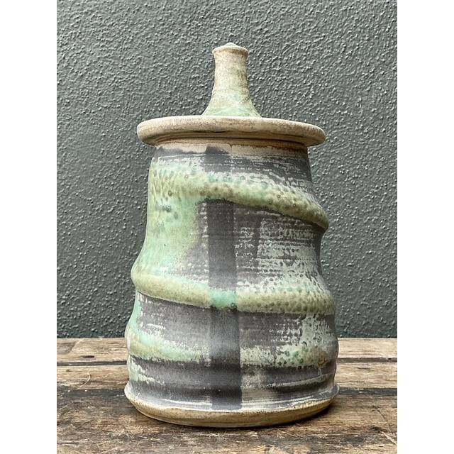 This exceptional vintage studio pottery lidded jar is a masterclass in organic modernism and tactile craftsmanship. Hand-...