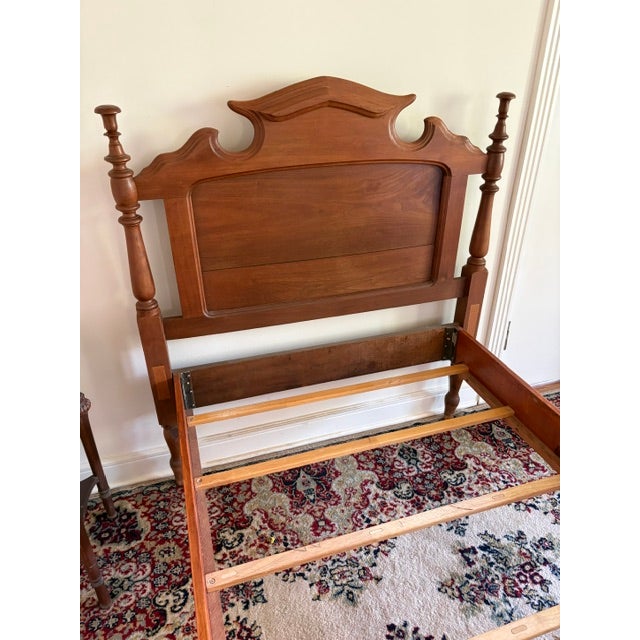 This antique twin bed features a scrolled headboard and low-post design. The head and footboards feature a cutout known as...