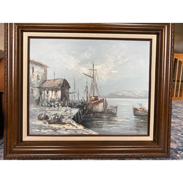 Vintage oil painting depicting a fishing harbor with boats moored along a dock. Executed with visible textured brushwork...