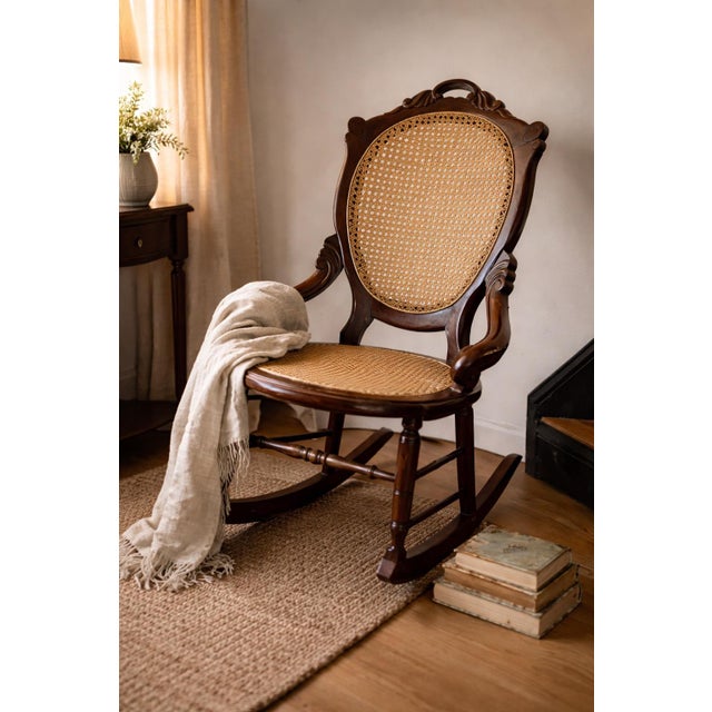 A beautifully sculpted antique Victorian Eastlake rocking chair, featuring an elegant oval cane back and seat framed by...