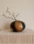 A striking oversized Sasaki Glass art glass vase featuring a dramatic low-profile orb silhouette with rich amber tones...