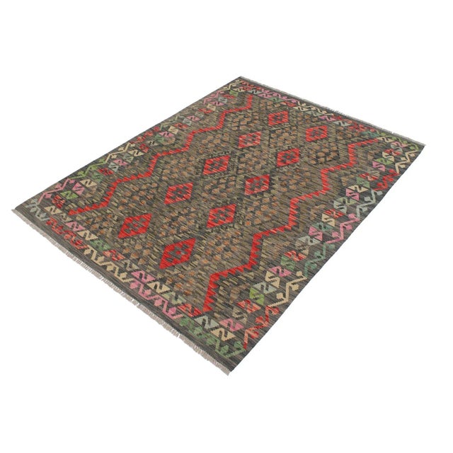 Add a touch of elegance to your home with this casual chic hand woven Tribal Kilim wool rug. Constructed on a loom by...