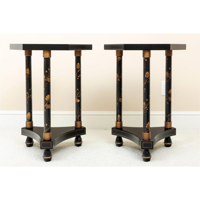 Pair of ebonized and parcel gilt side tables with hexagonal form top resting on round columns surmounted on a tripod base...
