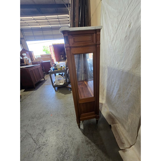 Late 20th-century French Directoire-style vitrine cabinet featuring a polished white marble top over a richly finished...