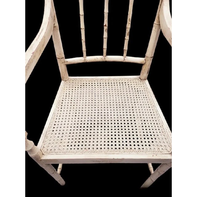 A wonderful regency distressed tan faux bamboo and cane side chair. The side chair has a tan finish with slighter darker...