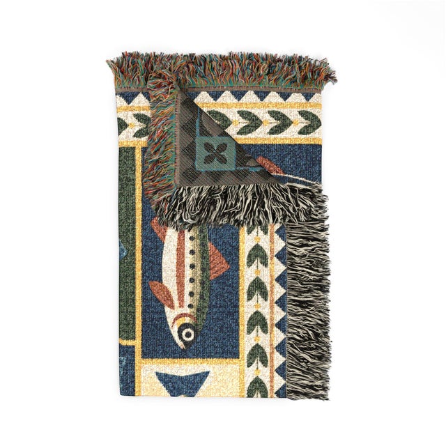 This folk art fish woven throw blanket features stylized fish in a patchwork arrangement of navy blue, forest green, rust,...