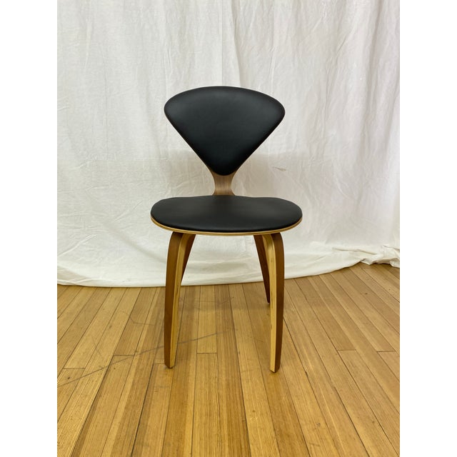 Nuevo satine dining chairs featuring black leather seats and an American walnut finish. Crafted with bent plywood...