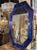 The product is a modern cobalt blue Murano glass octagonal mirror with brass details. The glistening glass adds a real...
